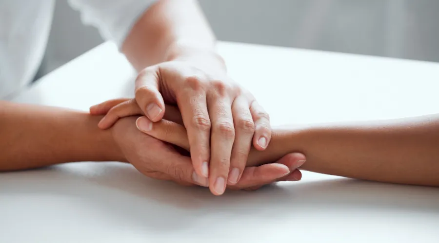 Detox center Georgia concept pic shows hands clasped in a comforting gesture