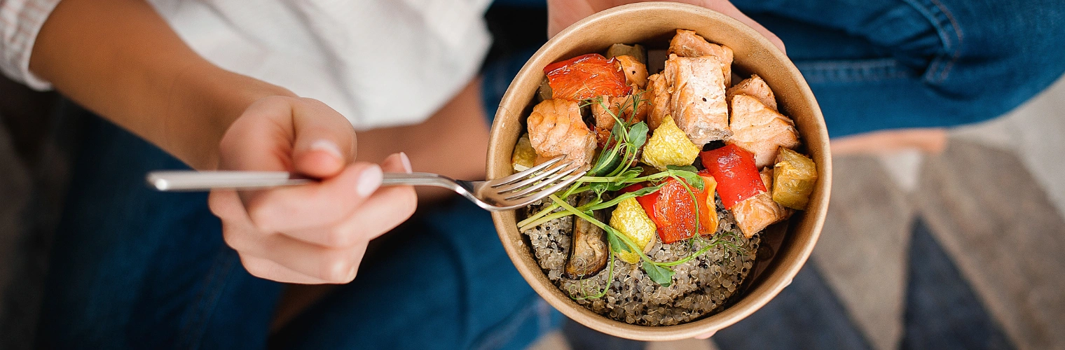 Female's hand holding a fork above a bowl of fish, rice and vegetables - Balanced Food Plates - Nutrition in Recovery