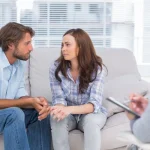 Image of a couple sitting on sofa with a counselor looking on - How to Get a Loved One into Drug Rehab or Alcohol Rehab