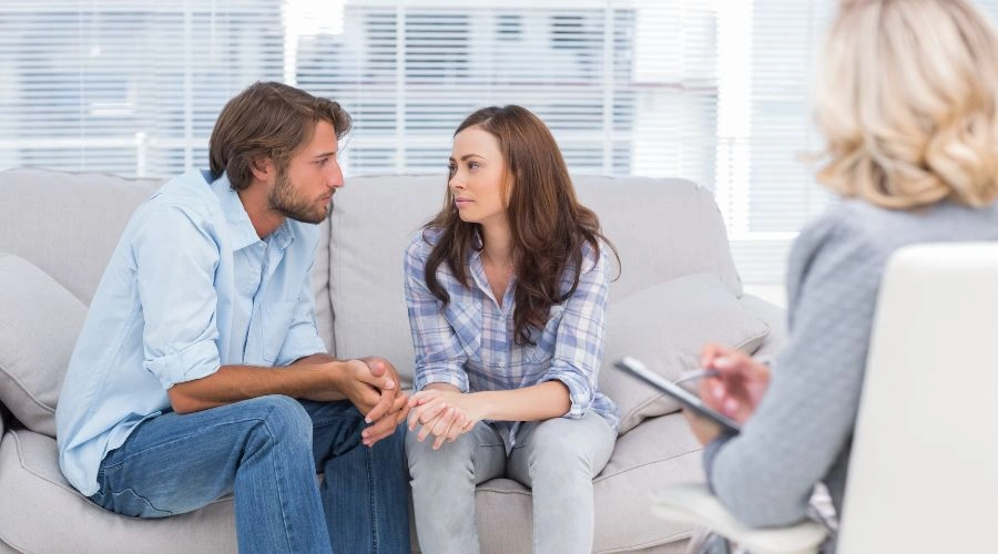 Image of a couple sitting on sofa with a counselor looking on - How to Get a Loved One into Drug Rehab or Alcohol Rehab
