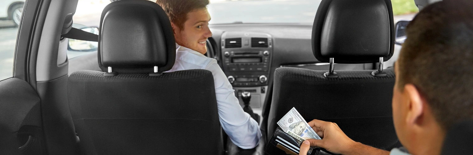 Image of a Passenger paying for service to a male taxi driver