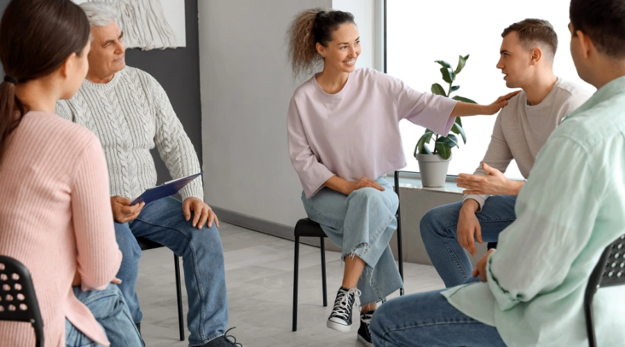 Image of men and women sitting in a circle  at an AA meeting