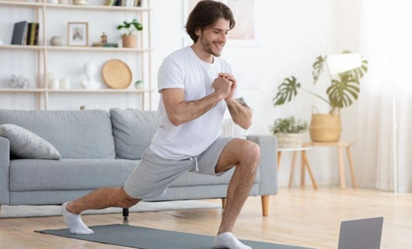 Image of a man on a yoga mat engaged in the yoga lunge pose - Advantage of 12 Step Recovery Yoga - Increased Self-Esteem