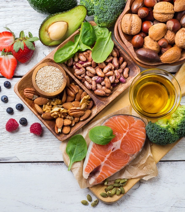 Foods That Help Manage Alcohol Cravings Image of nuts, fruits, vegetables, fish and beans in bowls and on a platter - Foods That Help Manage Alcohol Cravings
