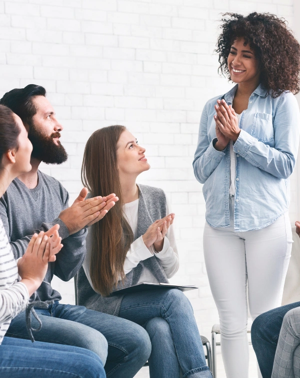 Group of women and men in prayer at an NA Meeting