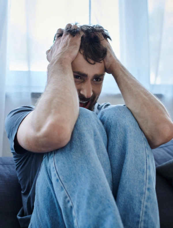 Mans sitting on the floor in anguish with hands on his head - Meth comedowns and effect on mental health