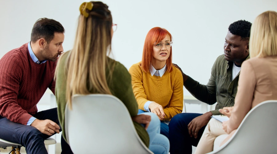 Image of men and women sitting in a circle at an AA meeting - What is a Sponsor in AA - Ingrained Recovery