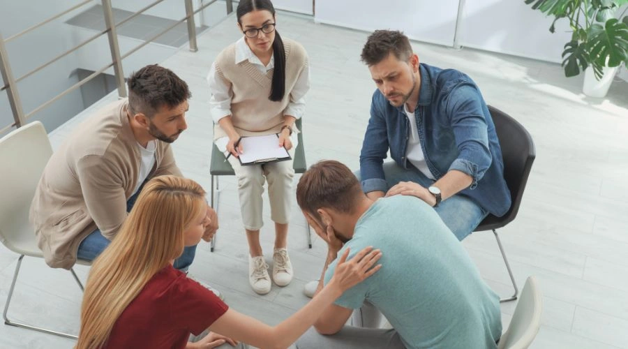 Image of a family member supporting a loved one during group therapy session