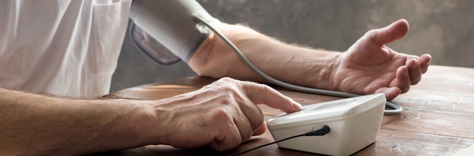 Image of a man checking his blood pressure