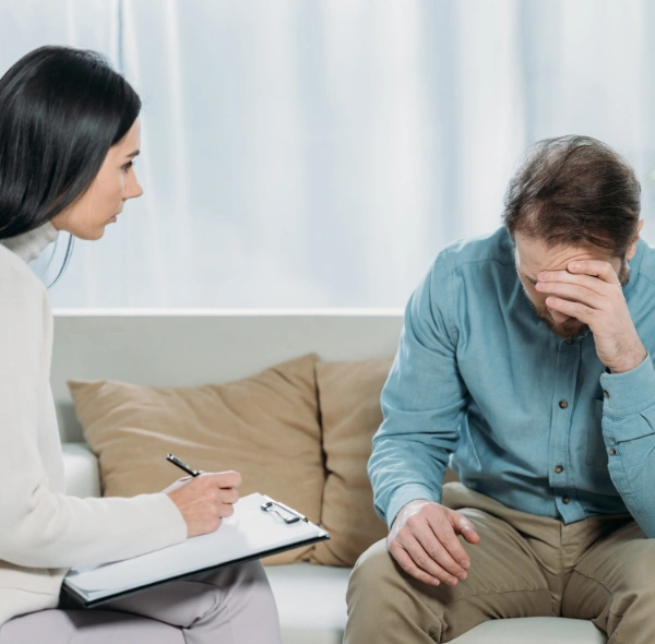 A therapist consulting with a patient about mental health treatment options covered by insurance Image of a counselor consulting with a patient about mental health treatment options covered by insurance