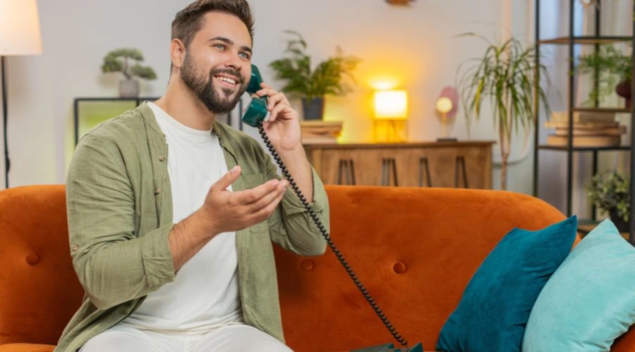 Person in a rehab facility making a phone call from a shared telephone to stay connected with family and friends