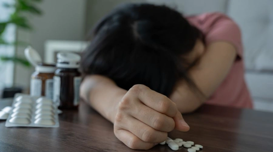 Person sitting alone looking distressed, illustrating depression, anxiety, and isolation linked to opioid misuse
