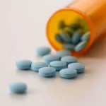 Image of Roxicodone pills on a table spilling out from a prescription bottle - What Are Roxies - Ingrained Recovery