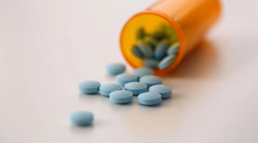 Image of Roxicodone pills on a table spilling out from a prescription bottle - What Are Roxies - Ingrained Recovery