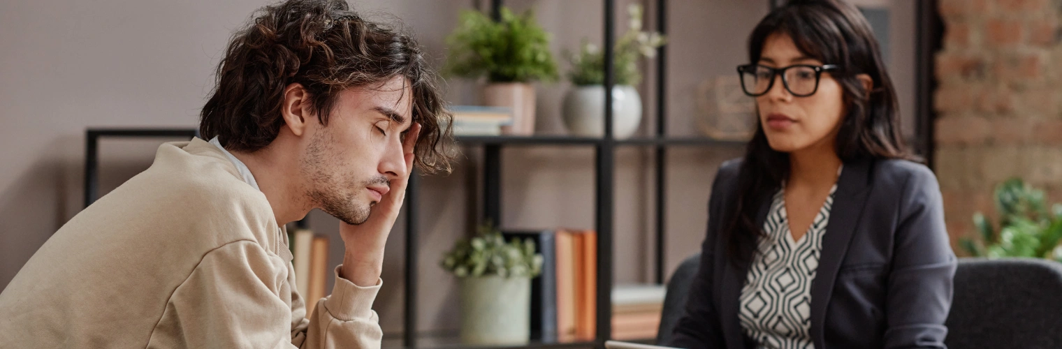 Rehab for Oil And Gas Workers - Ingrained Recovery Image of a male oil and gas worker sitting in therapy with a counselor - Rehab for Oil And Gas Workers - Ingrained Recovery