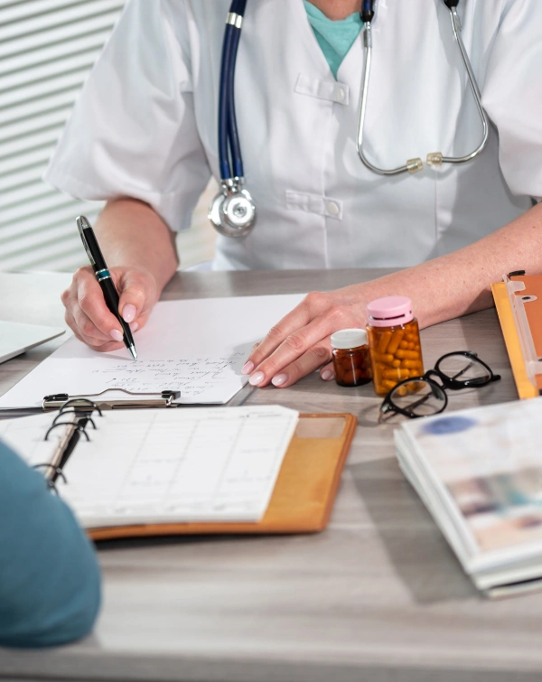 Doctor consulting a patient while reviewing prescription medications Image of physician consulting a patient while reviewing prescription medications