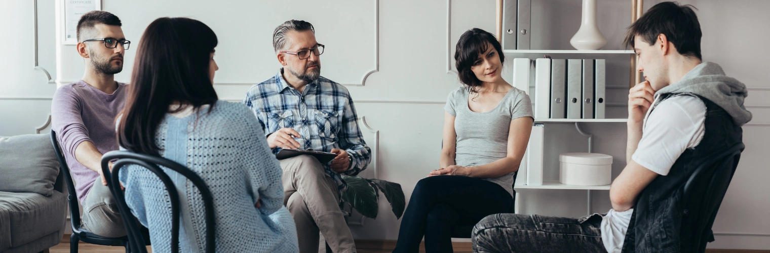 Family participating in a therapy session with a young adult Family participating in a therapy session with a young adult