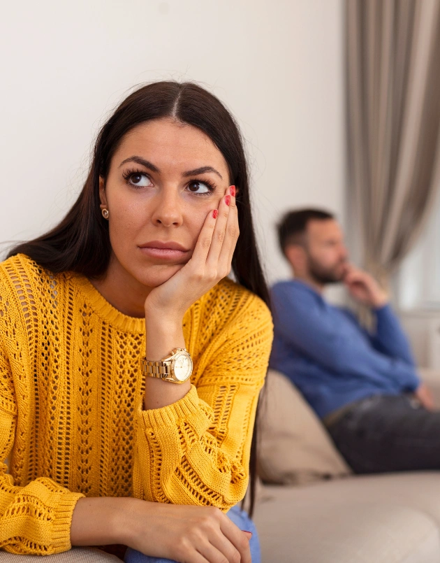 Image of a married couple sitting apart on a sofa - Can Addiction and Marriage Co-Exist?