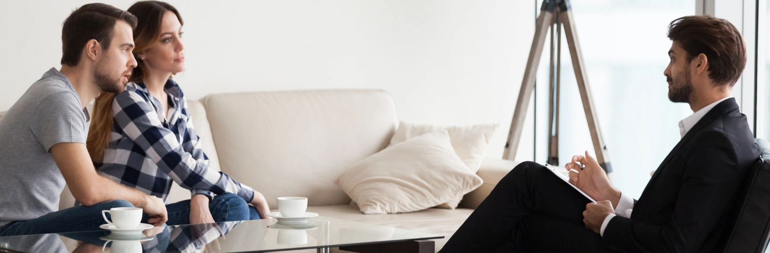 Image of a married couple sitting together in a supportive setting, symbolizing that marriages can survive addiction with treatment, honesty, and commitment to recovery Image of a married couple sitting together in couples therapy with a counselor