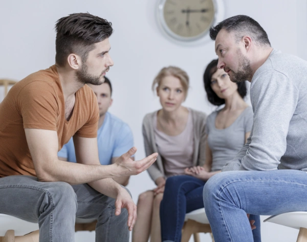 Image of addiction recovery group therapy role-play session where clients practice assertive communication and refusal skills Image of addiction recovery group therapy role-play session where patients practice assertive communication and refusal skills