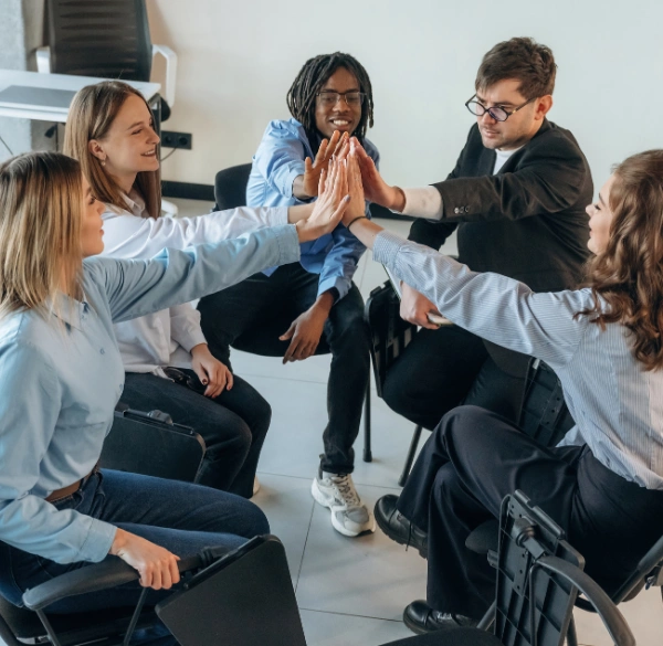 Image of group therapy participants raise hands to reflect common experiences