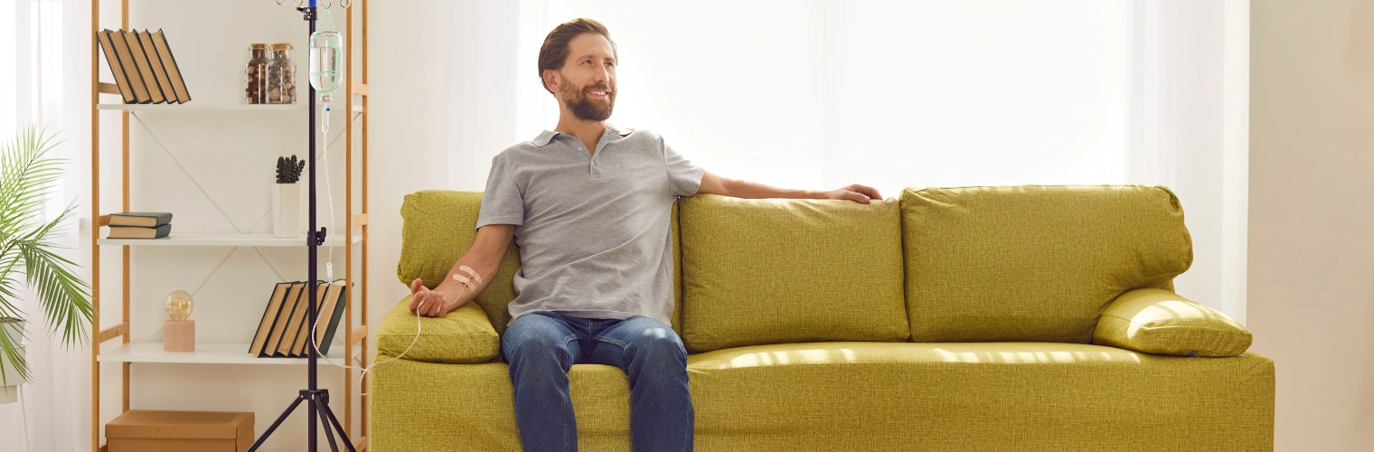 Image of a patient receiving NAD IV therapy during detox to support energy, healing, and recovery Image of a man sitting on a sofa, receiving NAD IV therapy during detox to support energy, healing, and recovery