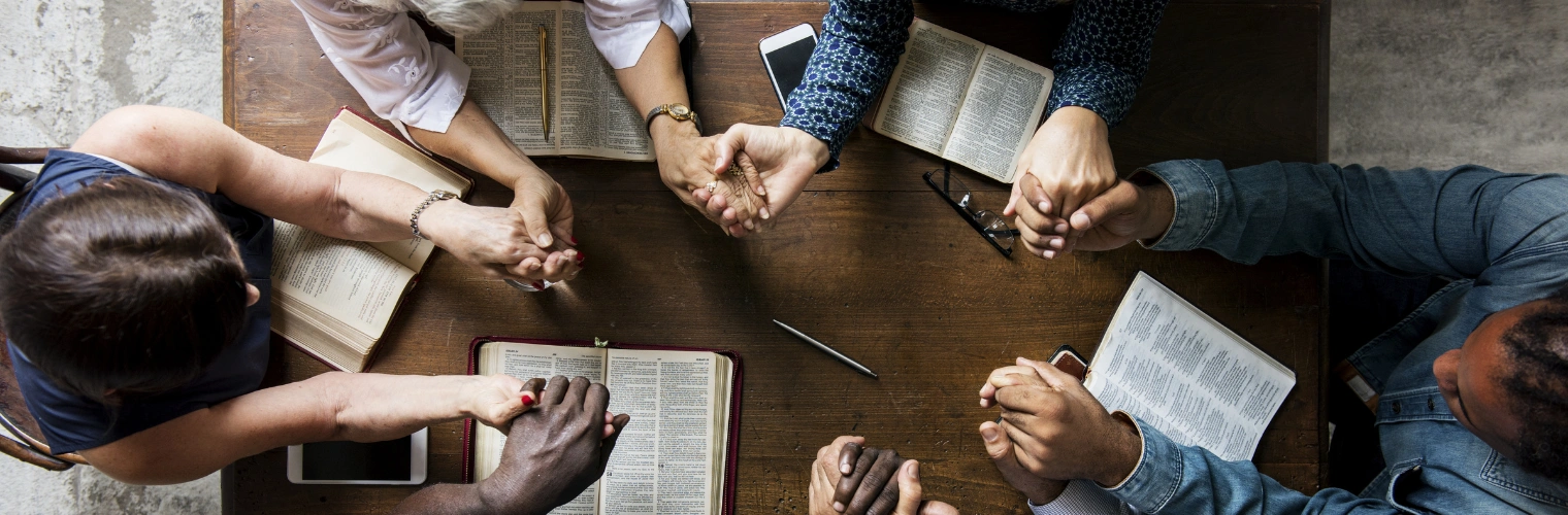 Image of spiritual principles and openness in AA Step Two Image of men and women's hands joined on a table, displaying the spiritual principles and openness in AA Step Two