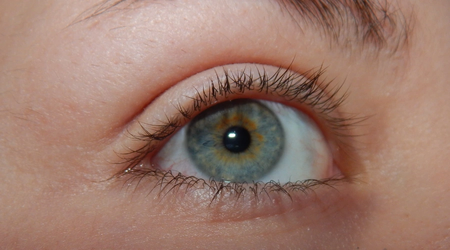 Image of a constricted or pinpoint pupil in a blue eye, illustrating how certain drugs and opioids can affect the central nervous system to cause miosis