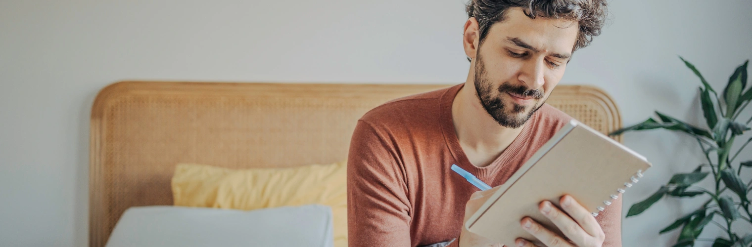 Image of a man writing in a journal during trauma therapy to process PTSD and difficult emotional experiences in recovery Image of a man writing in a journal during trauma therapy to process PTSD and difficult emotional experiences in recovery