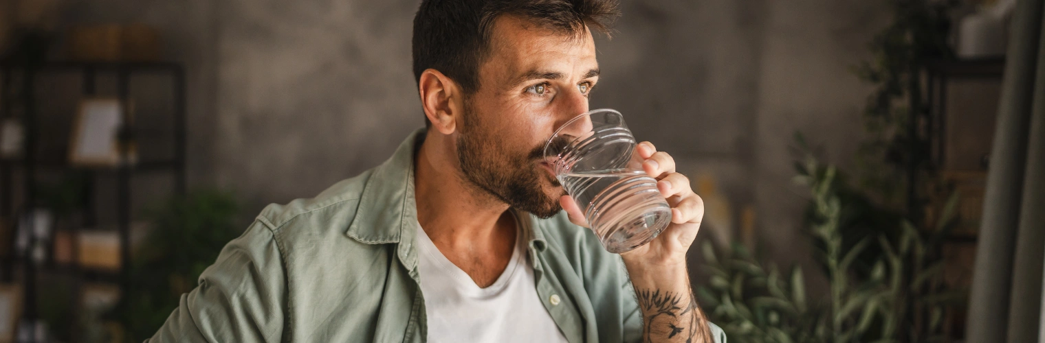 Image of a person sipping water and practicing calm breathing as practical coping steps during a greening out episode Image of a person sipping water and practicing calm breathing as practical coping steps during a greening out episode