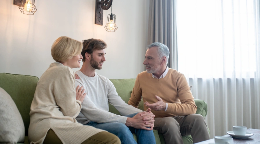 Image of a family sitting together in a calm, private space having an honest conversation about rehab