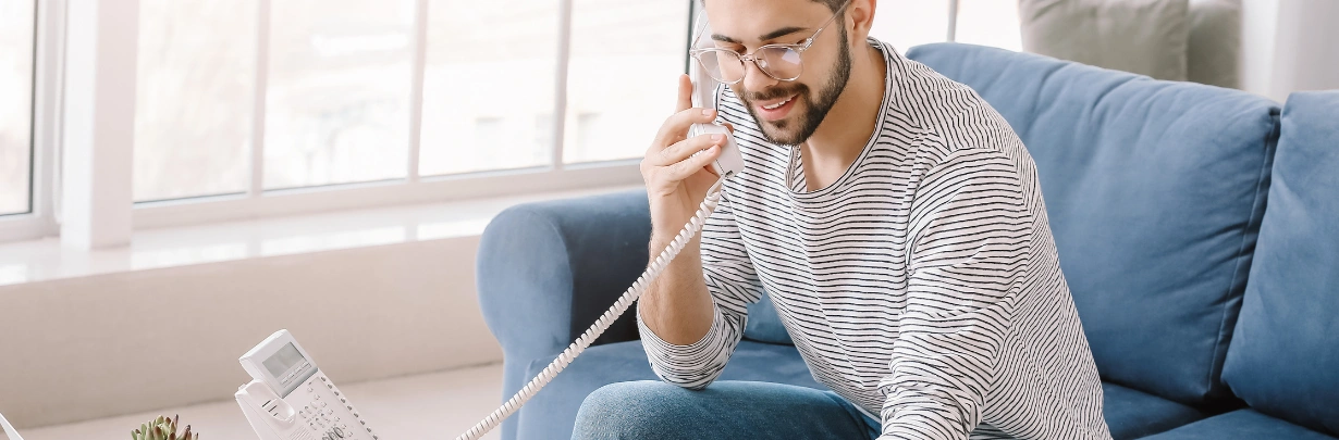 Image of a person taking notes during a phone call at home Image of a person taking notes during a phone call at home